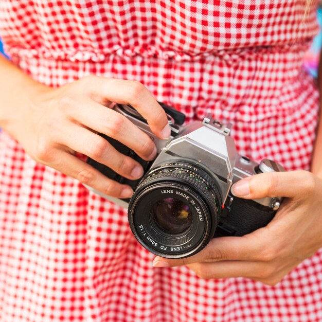 Close-up of woman holding camera in hand