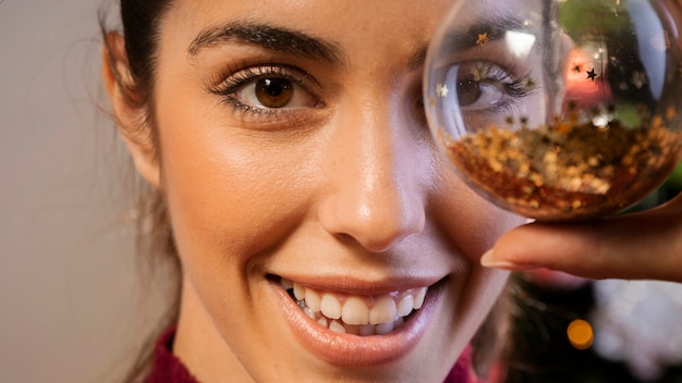 Free photo close-up woman holding christmas globe