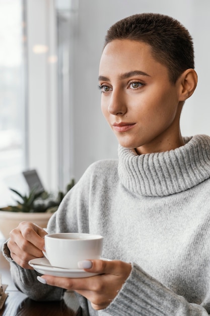 コーヒーカップを保持しているクローズアップの女性