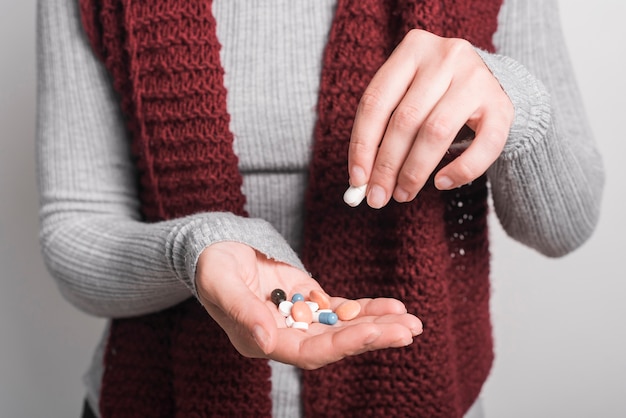 Foto gratuita primo piano della donna che tiene le pillole variopinte