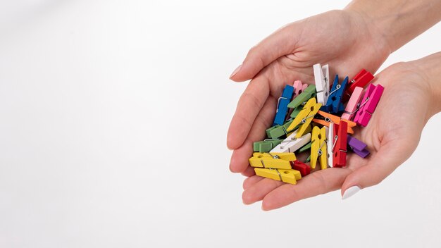 Close-up woman holding colourful clothes-pins