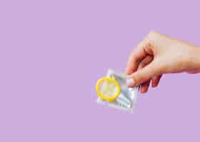 Free photo close-up woman holding condom with copy-space