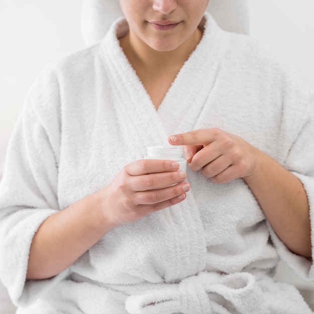 Foto gratuita donna del primo piano che tiene il contenitore della crema