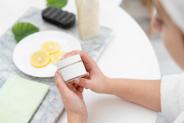 Close-up woman holding cream container