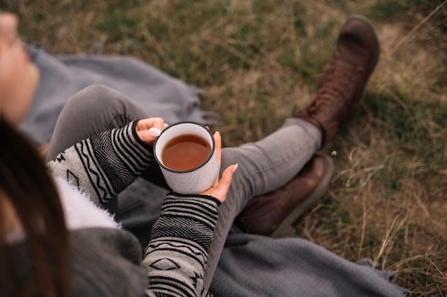 一杯のコーヒーを保持しているクローズアップの女性