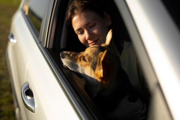 Close up woman holding dog in car
