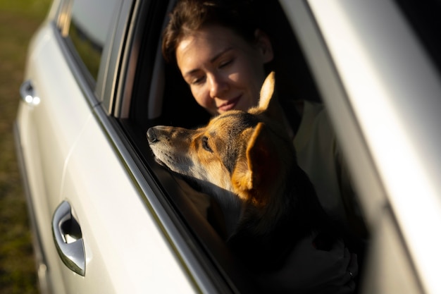 Close up woman holding dog in car