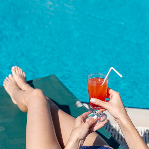 Free photo close up woman holding drink laying on lounge