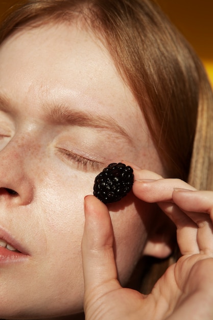 Close up woman holding fresh blackberry
