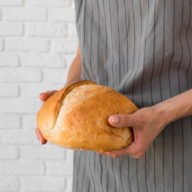 Крупным планом женщина, держащая свежий хлеб