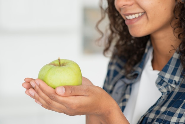 Крупным планом женщина, держащая зеленые яблоки