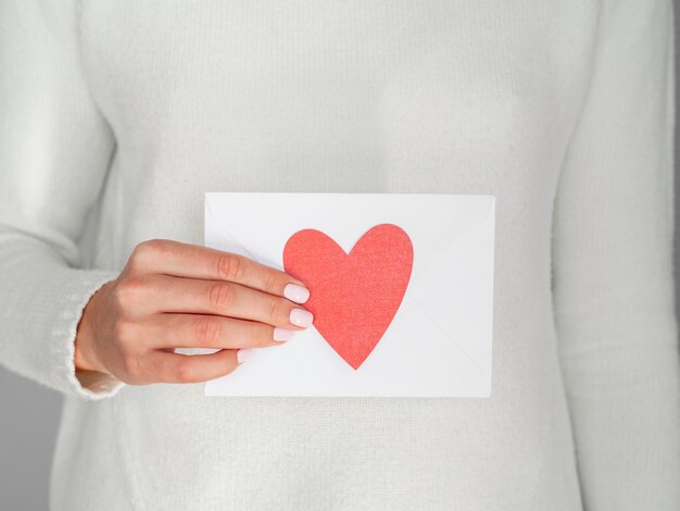 Close up woman holding heart envelope