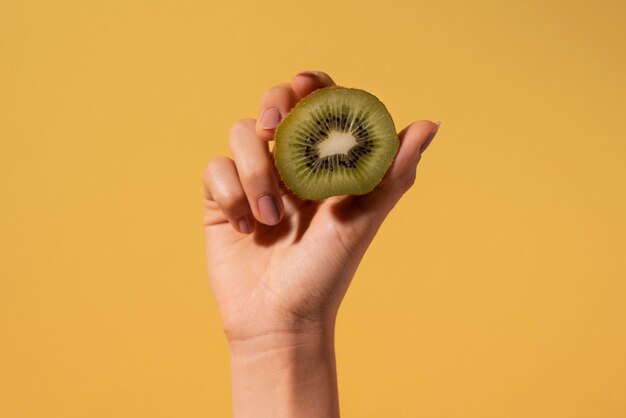 Close up woman holding kiwi