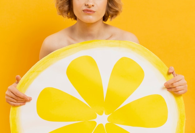 Foto gratuita fetta del limone della holding della donna del primo piano