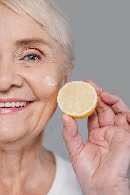 Close-up woman holding lemon slice