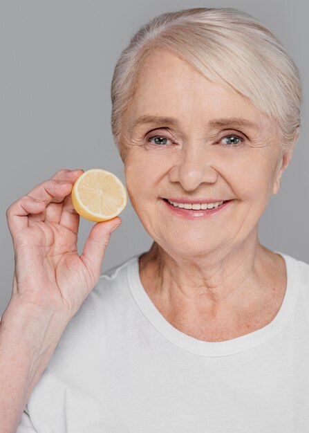 Close-up woman holding lemon slice