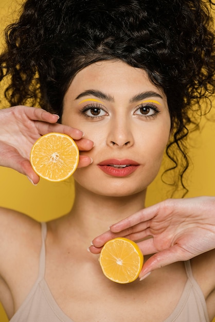 Foto gratuita donna del primo piano che tiene le fette di limone