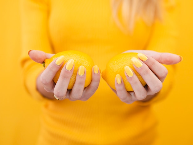 Крупным планом женщина, держащая лимоны