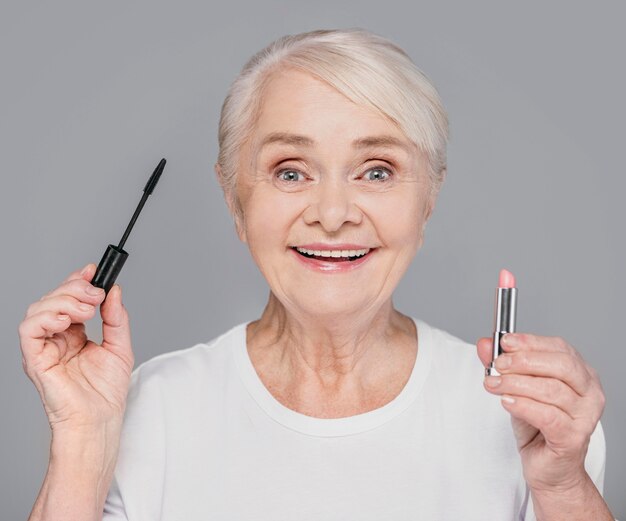 Close-up woman holding lipstick and mascara