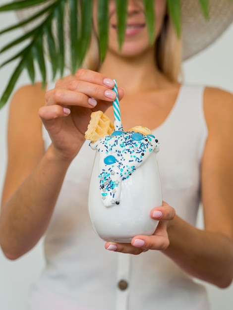 Close-up woman holding milkshake glass