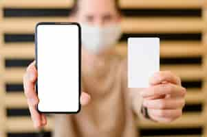 Free photo close-up woman holding mobile phone and card