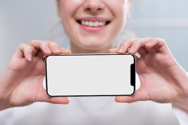 Free photo close-up woman holding mobile phone