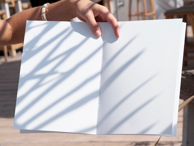 Close-up woman holding a mock-up magazine