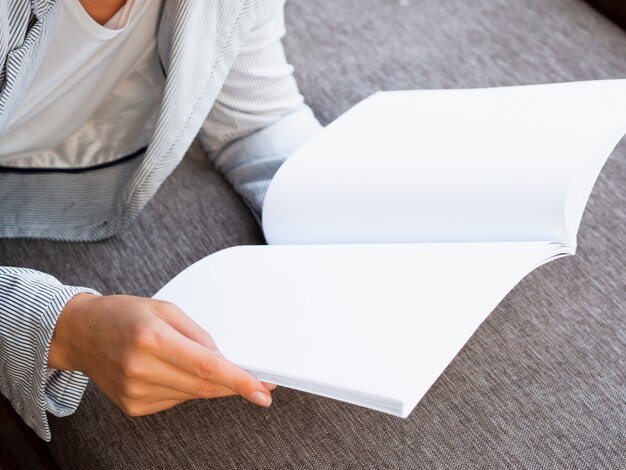 Close-up woman holding a mock-up magazine