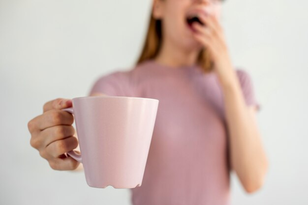 Foto gratuita tazza della holding della donna del primo piano