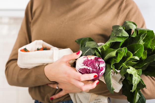 有機野菜を保持しているクローズアップの女性