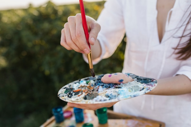 Foto gratuita tavolozza della pittura della tenuta della donna del primo piano