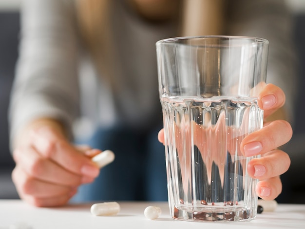 Close-up woman holding pill