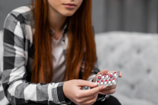 Close up of woman holding pills