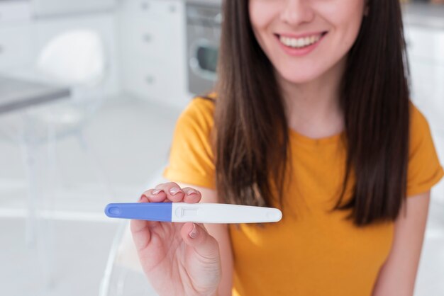 妊娠検査を保持している女性のクローズアップ