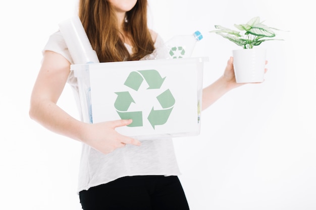 Free photo close-up of woman holding recycle crate and potted plant