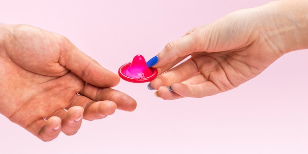 Close-up woman holding a red condom