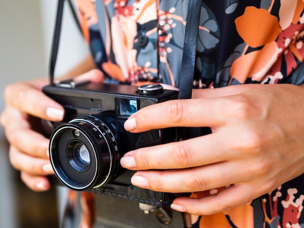 Close-up woman holding a retro photo camera