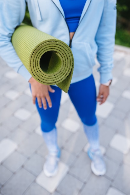 Close-up woman holding roll fitness after working