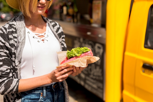 Foto gratuita donna del primo piano che tiene un panino