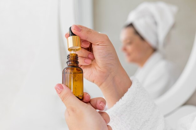 Close-up woman holding serum