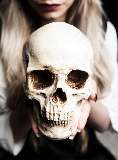 Close-up of woman holding skull