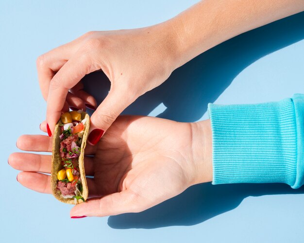 Close-up woman holding a small taco