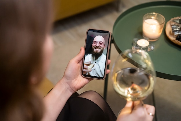 Close up woman holding smartphone and drink