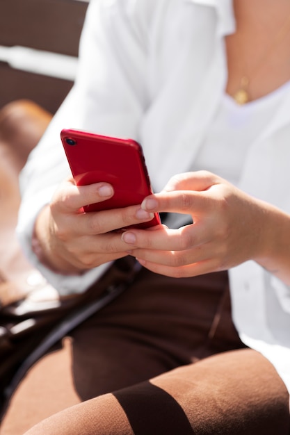 Foto gratuita primo piano donna che tiene smartphone