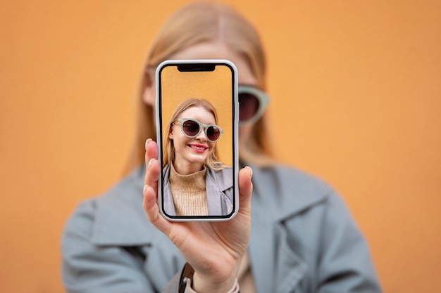 Free photo close up woman holding smartphone