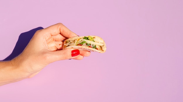 Close-up woman holding taco with copy-space