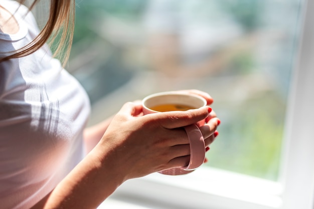 お茶を保持しているクローズアップの女性