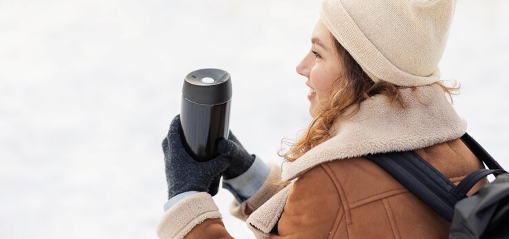 Free Photo close-up woman holding thermos