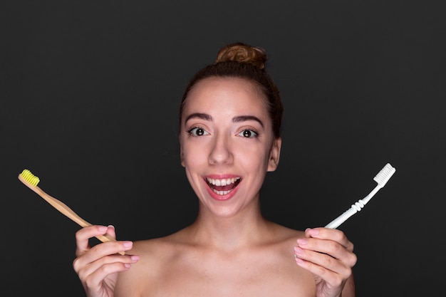 Close-up woman holding toothbrushes