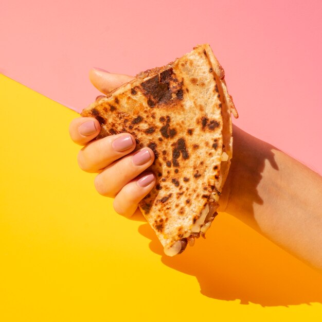 Close-up woman holding tortilla with colorful background